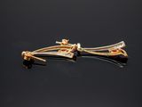 pair of gold and diamond earrings on a black surface