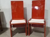 pair of orange chairs with white cushions in a room