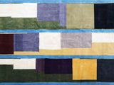 a blue rug with multicolored squares and squares on it