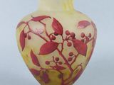 a yellow vase with red flowers on it on a white background