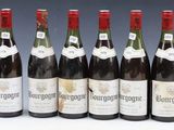 six bottles of wine lined up in a row on a table