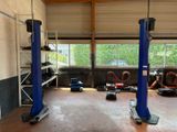 a garage with two blue lifts in the middle of the room