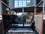 a black car with orange trims parked in front of a building