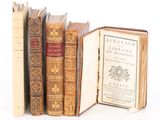 plusieurs vieux livres sont empilés sur une surface blanche