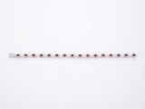 un gros plan d'un bracelet rouge et blanc posé sur une surface blanche