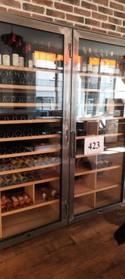Des bouteilles de vin sont exposées derrière des portes vitrées dans un caviste.