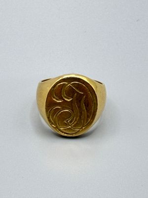 un gros plan d'une bague chevalière en or ornée d'un cheval