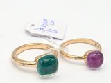 pair of emerald and amethorate rings with a price tag on a white background