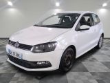 the white volkswagen polo is parked on a checkered tile floor