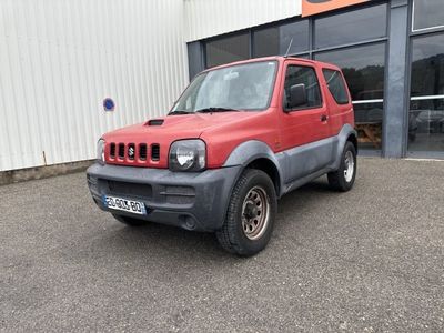 une photo d'une jeep rouge garée devant un immeuble