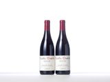two bottles of red wine sitting next to each other on a table