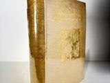 an old book sitting on top of a white table next to a white wall