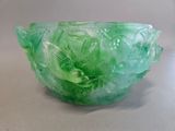 a green glass bowl sitting on a white surface