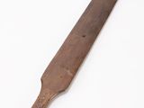 an old wooden knife on a white surface with a white background