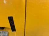 a close up of a yellow refrigerator with a remote control