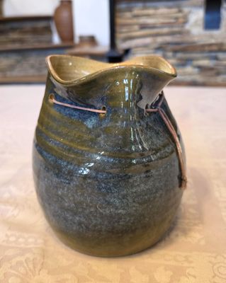 un vase bleu et vert posé sur une table
