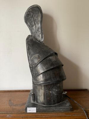 une statue représentant le casque d'un chevalier posée sur une table en bois