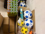 a box full of soccer balls and other items on the floor