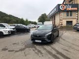 une voiture noire garée devant un bâtiment dans un parking