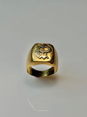 a close up of a gold ring on a white surface