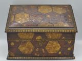 une vieille boîte en bois ornée de motifs dorés et noirs