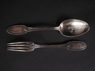 deux cuillères et une fourchette posées sur une surface noire
