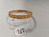un gros plan d'une bague en or posée sur un socle transparent