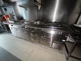 une grande cuisinière en inox au milieu de la cuisine