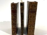two old books sitting side by side on a white surface