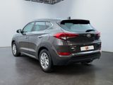 the back end of a gray car in a white room