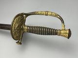 a close up of a sword on a white surface