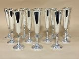 six verres à vin en argent sont alignés sur une table