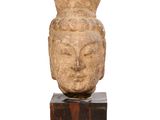 une image représentant une statue d'une tête posée sur un socle en bois