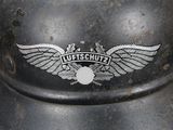 a close up of a metal helmet with a logo on it