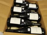 plusieurs bouteilles de vin se trouvent dans un carton sur une table