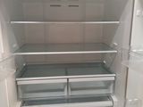 an open refrigerator with the door open and no food inside