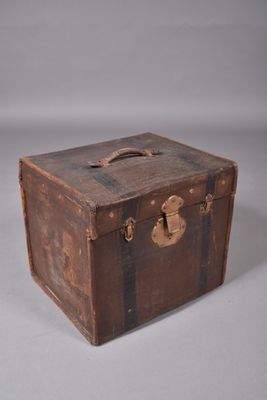 une vieille valise posée sur une table, sur fond blanc
