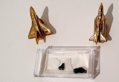 deux navettes spatiales dorées sur une surface blanche
