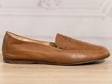 a close up of a pair of brown shoes on a wooden table
