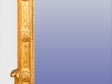 an ornate gold framed mirror with a blue background