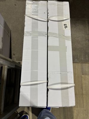 une personne debout à côté d'une pile de cartons sur un tapis roulant