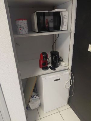 a microwave and a mini fridge in the corner of a room