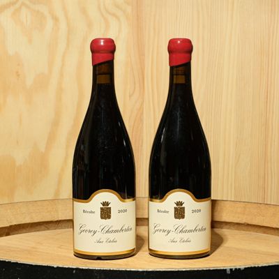 deux bouteilles de vin posées sur un tonneau en bois