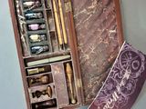 une boîte en bois contenant un stylo et quelques autres objets