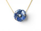 a close up of a blue flower necklace on a gold chain