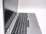 a silver laptop with a black keyboard on a white surface