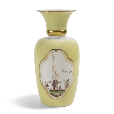 un vase jaune orné d'un motif sur fond blanc