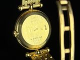 a close up of a gold watch on a black surface