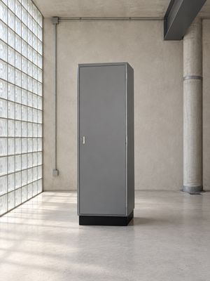 une grande armoire métallique dans une pièce dont l'un des murs est constitué de briques de verre