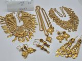 quelques bijoux en or sont posés sur une surface blanche